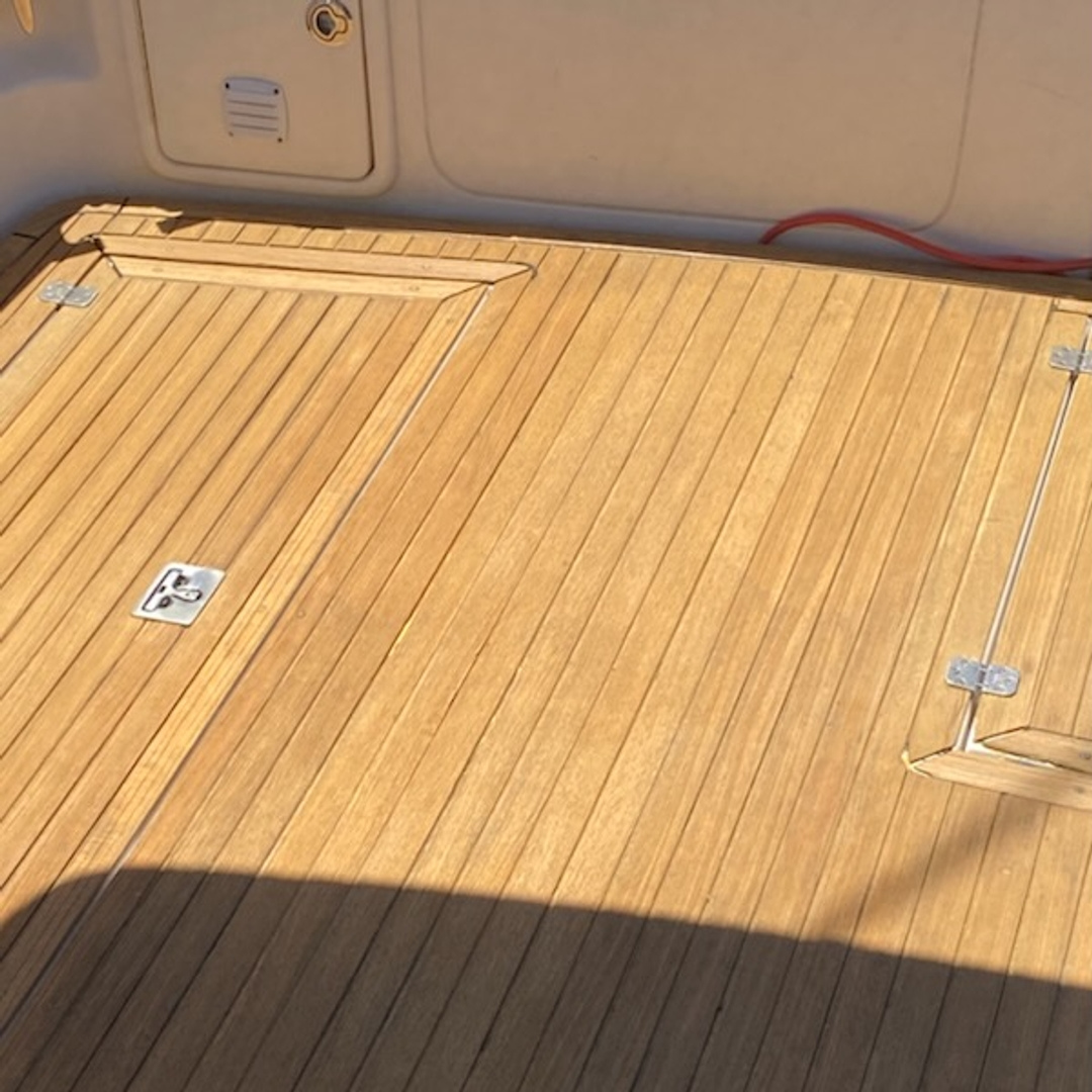 After deck of old teak deck on a large boat with a fresh coat of Natural Semco Teak Sealer applied to restore it from grey.